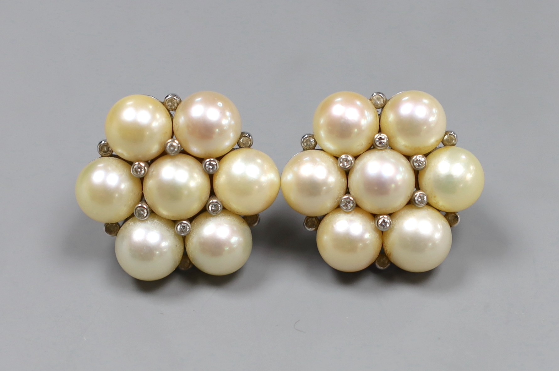 A pair of Indian white metal, cultured pearl and diamond chip cluster earrings, gross 22.7 grams, diameter 2.5cm